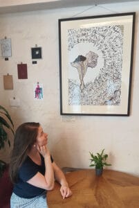 Expresivní kaligrafie kombinovaná s kresbou. Báseň od Emily Dickinson tvoří mycelium, které obklopuje kresbu hlívy plicní. Veronika Wuycheck se svým kaligrafickým obrazem The Mushroom is the Elf of Plants & Hlíva plicní